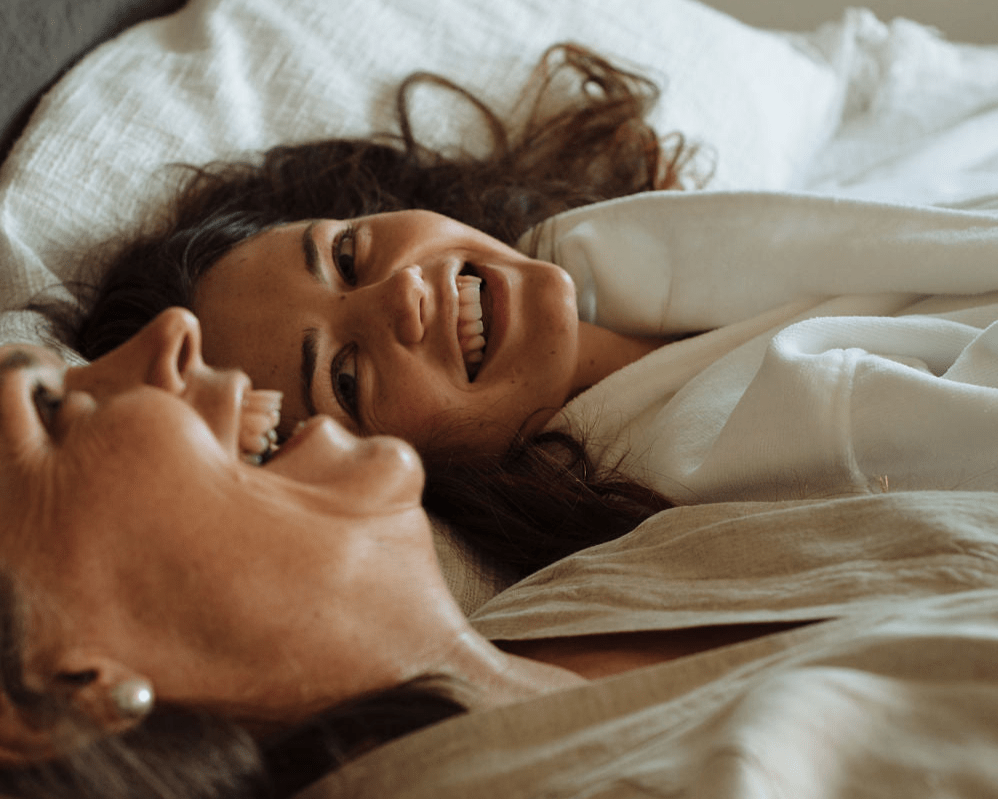 Happy women lying on a bed